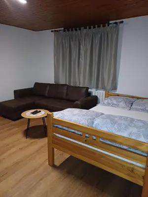 a bedroom with a bed and a couch and a table at KaTi Hiša