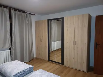 a bedroom with a mirror and some wooden cabinets at KaTi Hiša