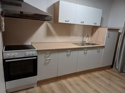 a kitchen with white cabinets and a stove and a sink at KaTi Hiša