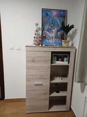 a wooden dresser with a television in a room at KaTi Hiša