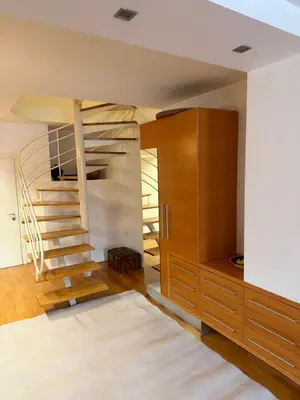 a room with a spiral staircase and a wooden cabinet at Ekoviki in Kranj