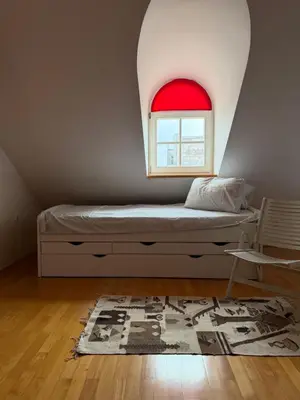 a bedroom with a bed with a red window at Ekoviki in Kranj