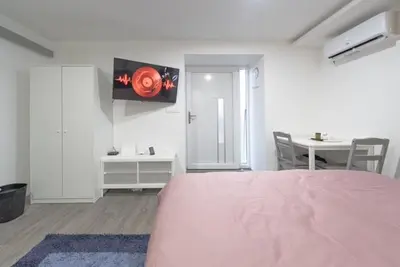 a bedroom with a pink bed and a table and a table at Rooms Nonna Bled in Bled