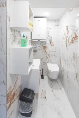 a white bathroom with a toilet and a sink at Rooms Nonna Bled in Bled