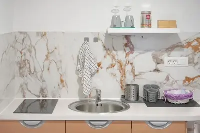 a kitchen counter with a sink and a marble wall at Rooms Nonna Bled in Bled
