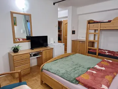 a bedroom with a bed and a desk with a television at Mia's room in Zreče