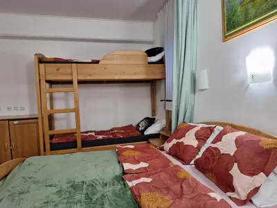 a bedroom with two bunk beds and a bed at Mia's room in Zreče
