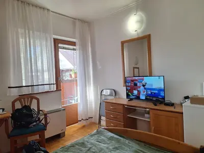 a bedroom with a desk with a television on it at Mia's room in Zreče