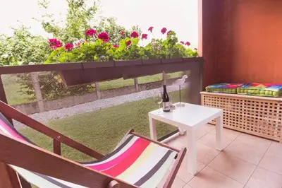 a balcony with a chair and a table and a window at Ljubljanica Apartment in Ljubljana