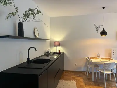 a kitchen with a sink and a table with chairs at Ljubljanica Apartment in Ljubljana