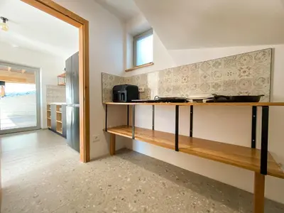 a kitchen with wooden shelves and a refrigerator at KOČA ODMEV Obolno in Ivančna Gorica