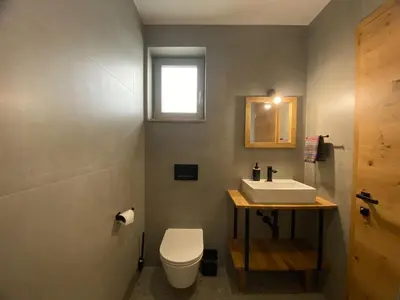 a bathroom with a white sink and a toilet at KOČA ODMEV Obolno in Ivančna Gorica