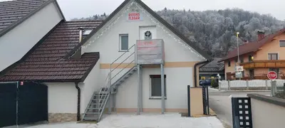 a building with a sign on the side of it at Flegarrooms in Cerklje na Gorenjskem