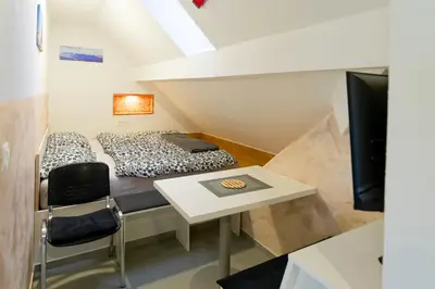 a room with a bed and a table and a tv at Flegarrooms in Cerklje na Gorenjskem