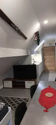 a living room with a table and a tv in a room at Flegarrooms in Cerklje na Gorenjskem