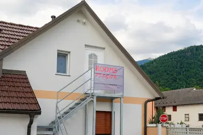 a white building with a room fight sign on it at Flegarrooms in Cerklje na Gorenjskem