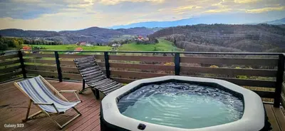 a hot tub and two chairs on a deck with a view at Holiday home in Trzisce - Kranjska (Krain) 54981
