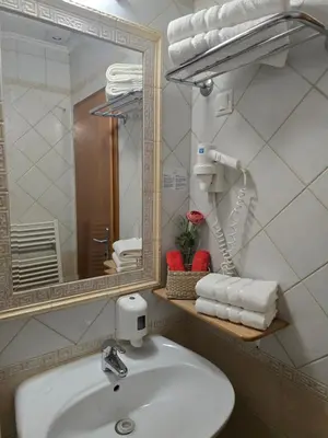 a bathroom with a sink and a mirror and towels at Cozy Nook Stays, Ski rent, med Roglo in Termami Zreče, in Zreče