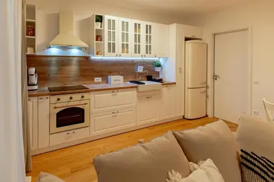a kitchen with white cabinets and a white refrigerator at Anur Apartment II in Ptuj