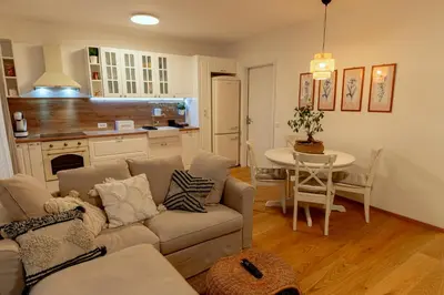 a living room and kitchen with a couch and a table at Anur Apartment II in Ptuj