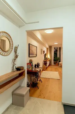 a living room with a table and a mirror at Anur Apartment II in Ptuj