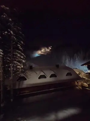 a train is covered in snow at night at Apartma JOŠT GOLTE in Mozirje