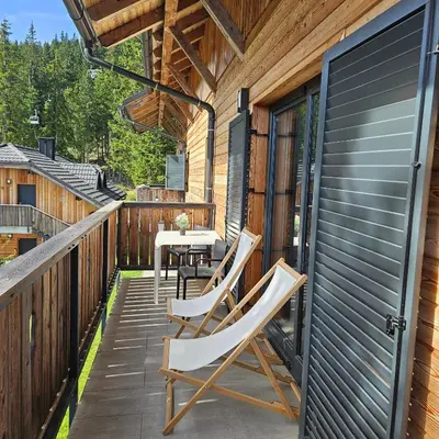 a patio with chairs and a table on a house at Apartma JOŠT GOLTE in Mozirje
