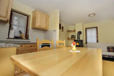 a kitchen with a wooden table with a vase on it at Ekološka turistična kmetija pri Lovrču in Tolmin