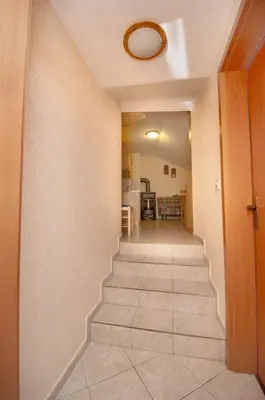 a hallway with stairs leading to a living room at Ekološka turistična kmetija pri Lovrču in Tolmin