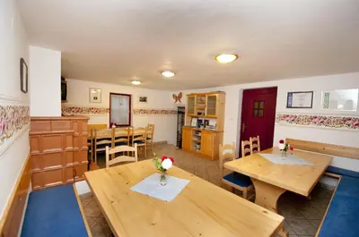 a living room with wooden tables and a kitchen at Ekološka turistična kmetija pri Lovrču in Tolmin