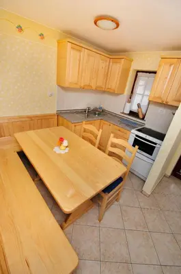 a kitchen with a wooden table and a stove at Ekološka turistična kmetija pri Lovrču in Tolmin