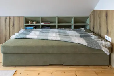 a bedroom with a large green bed with shelves at Počitniška hiša Gorski Šepet Bled in Bled