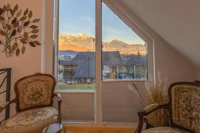 a room with two chairs and a large window at Počitniška hiša Gorski Šepet Bled in Bled