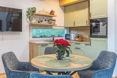 a kitchen with a table with a vase of flowers on it at Počitniška hiša Gorski Šepet Bled in Bled