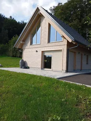 a house with a large window and a garage at Počitniška hiša Gorski Šepet Bled in Bled