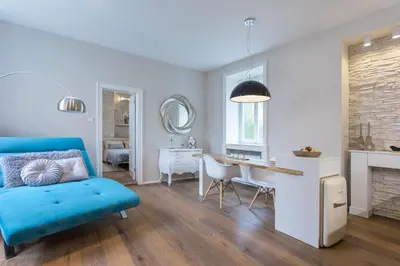 a living room with a blue couch and a desk at Elegant Castle Nook in Ljubljana