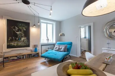 a living room with a table and a blue chair at Elegant Castle Nook in Ljubljana