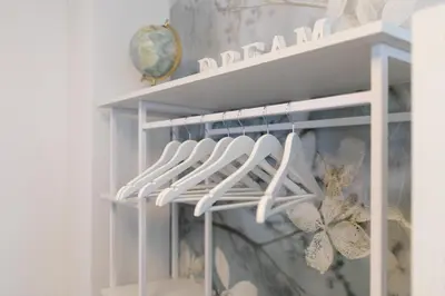 a white rack with white hangers in a room at Elegant Castle Nook in Ljubljana