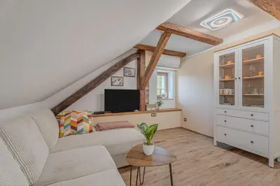 a living room with a couch and a tv at Vila Trate with Shared Pool and Garden in Ljutomer
