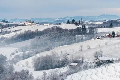 a snow covered hillside with houses on it at Vila Trate with Shared Pool and Garden in Ljutomer
