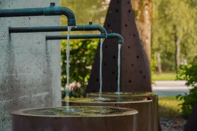 a small water fountain in a park with asevere at Guest House Tri Zvezde in Kočevje