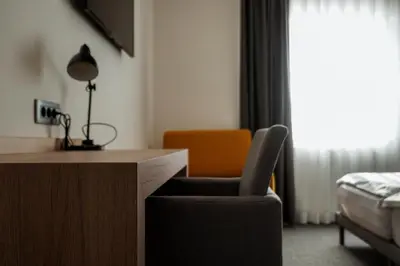 a room with a desk and a chair and a bed at Guest House Tri Zvezde in Kočevje