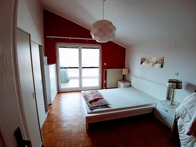 a bedroom with a bed and a large window at House Godec in Ljubljana