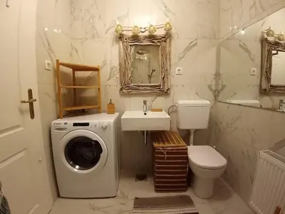 a bathroom with a washing machine and a sink at House Godec in Ljubljana