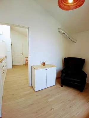 a living room with a black chair and a table at House Godec in Ljubljana