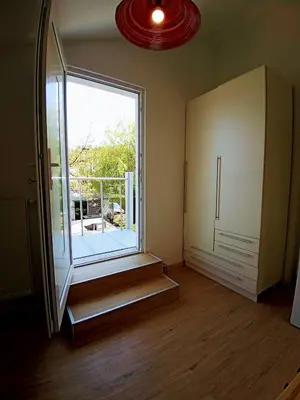 an empty room with a large window and wooden floors at House Godec in Ljubljana