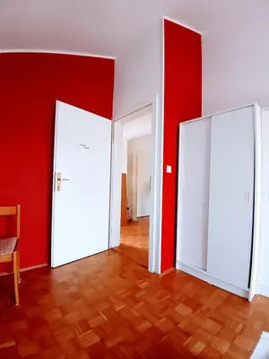 an empty room with two white doors and red walls at House Godec in Ljubljana