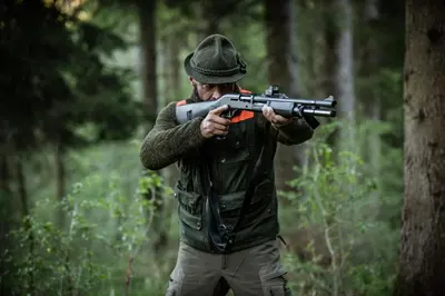 a man holding a gun in the woods at LYNX PRO - Basecamp units in Rove