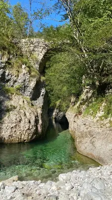 a bridge over a river with green water at Room Pstina in Slappe dʼIdria