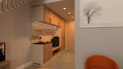 a hallway with a room with a tv and a chair at Butični gorski spa hotel Rimski vrelec in Kotlje